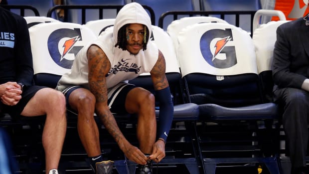 Grizzlies guard Ja Morant ties his shoes during warmups.